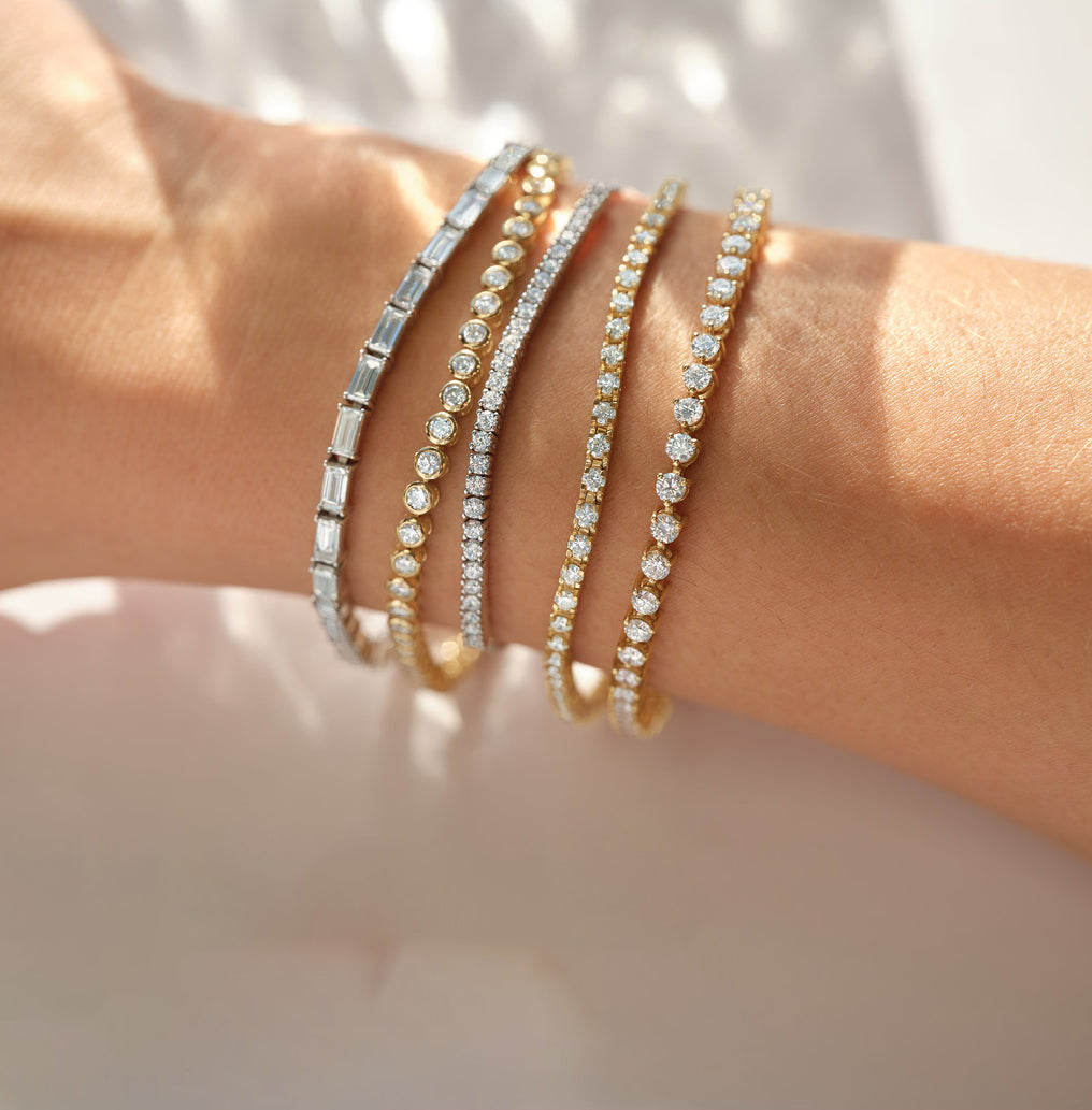 Multiple tennis bracelets adorning a woman's arm, adding sparkle and elegance to her ensemble