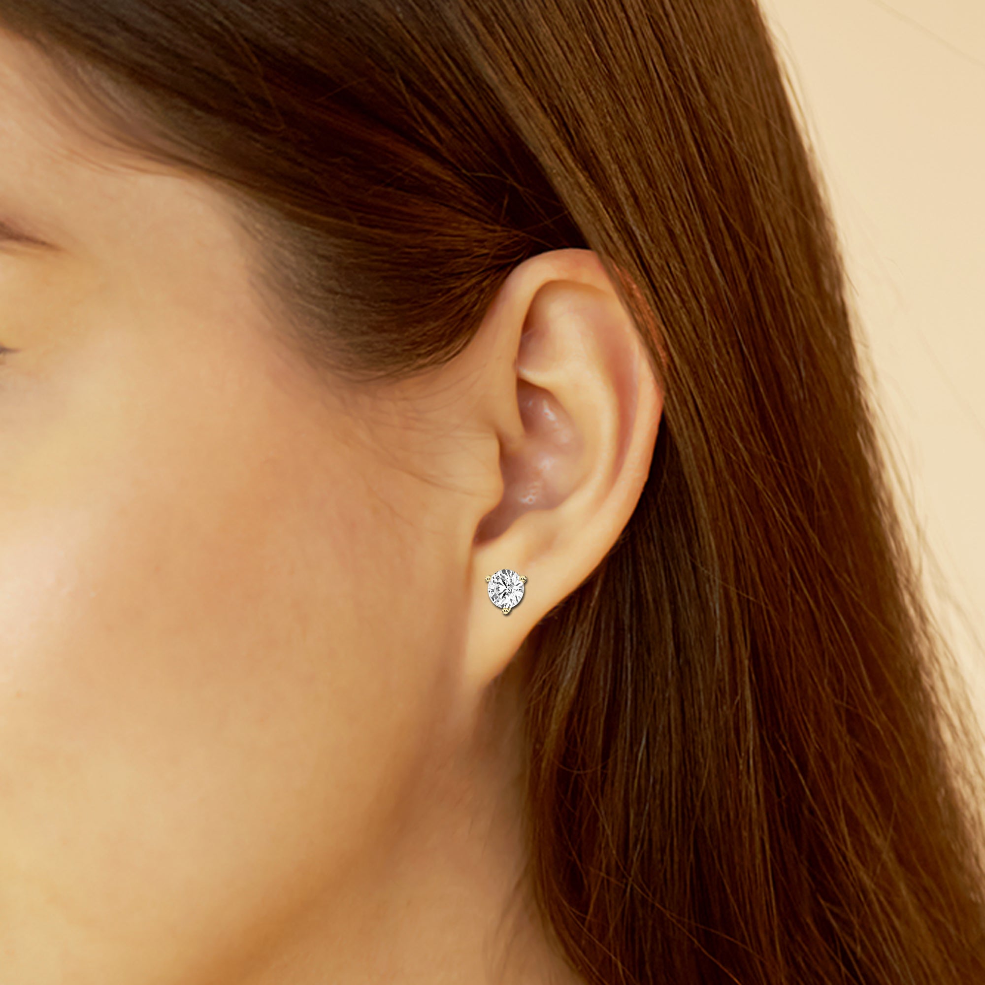 woman wearing Yellow gold stud earrings adorned with 1.5 carat lab-grown round diamonds